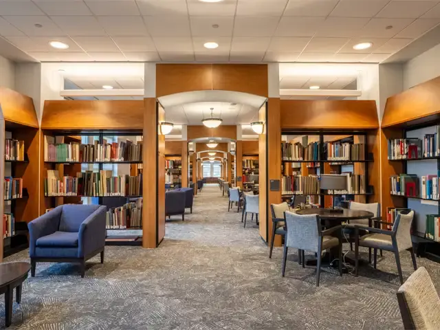 Image of study tables in the Quiet Corridor surrounded by some of our browseable collection items on shelves